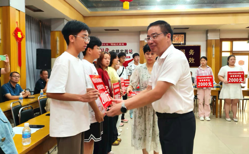 公司领导向学子们发放爱心助学金